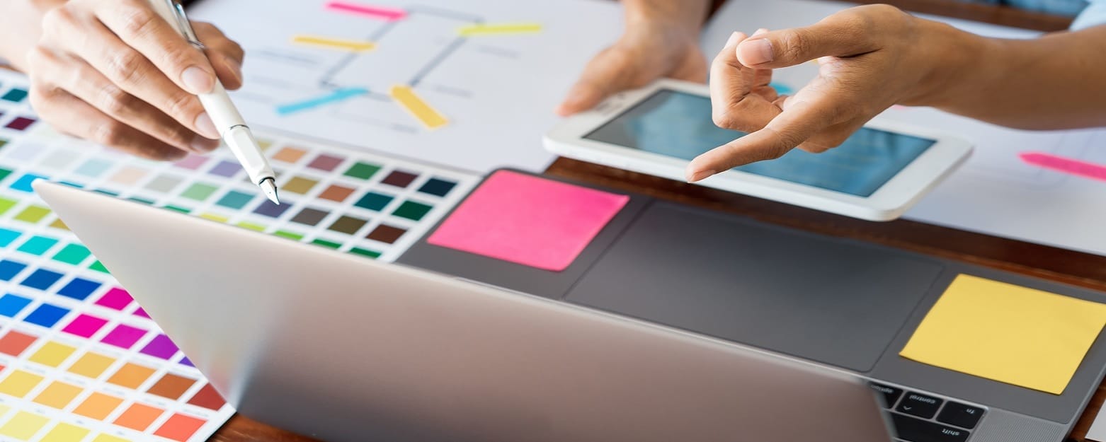 Hands at computer and smartphone choosing colors for web design